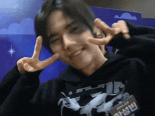 a man wearing a black hoodie with a name tag that says ' aisha kim ' on it