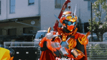 a man in a red and yellow costume is standing in front of a building