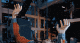 a man in a plaid shirt holds his hands up