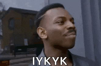 a man with a mustache is making a funny face with the word iykyk written on his face .
