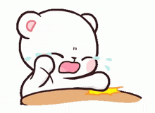 a cartoon teddy bear is crying while sitting on a table .