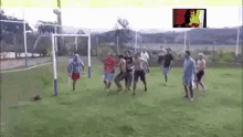 a group of people are playing soccer on a field with a goal in the background .