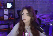 a woman is sitting in front of a microphone and looking at the camera .