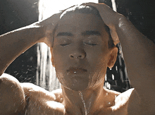a man takes a shower with his eyes closed