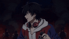a man wearing headphones and a jacket that says 01 and 86 holds a microphone