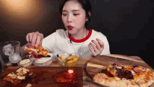 a woman is sitting at a table eating a slice of pizza