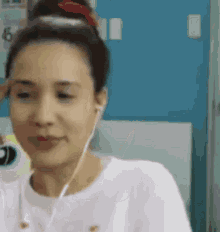a woman is wearing headphones and smiling while looking at the camera .