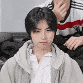 a boy wearing a white shirt with a red and white striped shirt that says ' manchester united ' on it