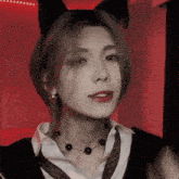 a woman wearing a cat ear headband and a necklace with black beads