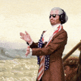 a man wearing sunglasses and headphones stands in front of a boat