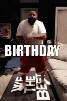 a man is dancing in front of a sign that says birthday on it