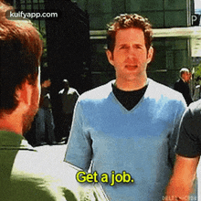a man in a blue sweater is talking to another man and saying `` get a job . ''