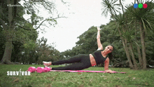 a woman is doing a plank on a yoga mat in a park with the word survivor in the corner