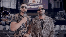 two men are standing in front of a aew sign