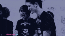 a group of people are laughing and one of them is wearing a shirt that says one ok rock ltd