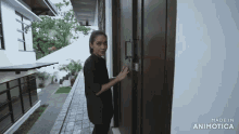 a woman is standing in front of a door that says made in animatica