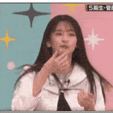 a girl in a white shirt and black tie is eating an apple .
