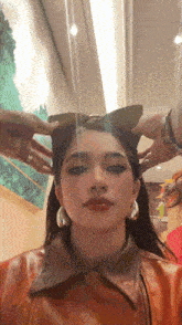 a woman wearing a cat ear headband and earrings takes a selfie