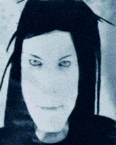 a close up of a person 's face with blue eyes and black hair