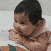 a baby is laying on its stomach on a bed