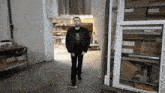 a man in a welless shirt walks through a doorway