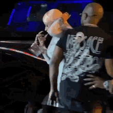 a man wearing a black versace shirt is standing next to another man