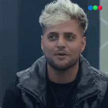 a man with blonde hair and a beard is looking at the camera