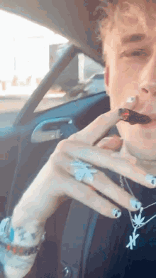 a man with white nails is smoking a cigarette in a car ..