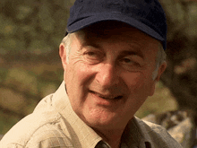 a man wearing a blue hat and a plaid shirt is smiling
