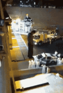 a blurred image of a man standing in front of a yellow truck