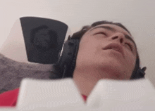 a man wearing headphones looks up at the camera