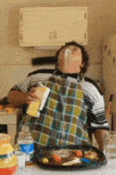 a man in a plaid apron is drinking milk
