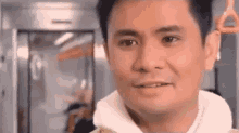 a man is smiling while riding a subway train .