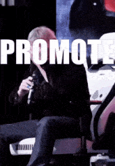 a man sitting in a chair with the word promote on the screen