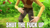 a cartoon character is standing in the grass with the words `` shut the fuck up '' written on the screen .