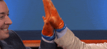 two men in suits and ties are sitting at a table giving each other a high five