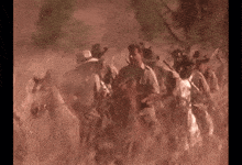 a group of cowboys are riding horses in a field