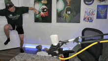 a man is jumping in the air in front of a microphone in a room with posters on the wall