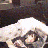 a person is laying on a couch with korean writing on the bottom