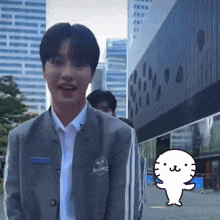 a boy in a school uniform is standing in front of a building with a cartoon cat behind him .
