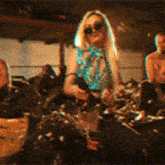 a woman wearing sunglasses sits on a couch with a man standing behind her