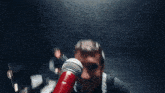 a man is singing into a microphone while playing drums .