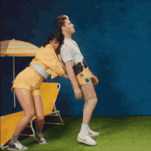 a man and woman are dancing in front of a beach chair
