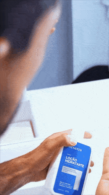 a man is holding a bottle of hensted loção hidratante