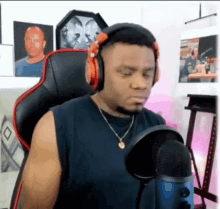 a man wearing headphones is sitting in a chair in front of a microphone .