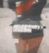 a blurry picture of a person standing next to a table with a bottle of alcohol in the background .
