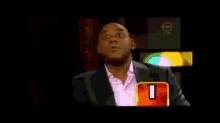 a man in a suit says " definitely " in front of a 0