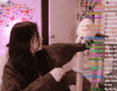 a woman is standing in front of a cat tree with a bunch of messages on the screen