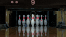 a bowling alley with the number 9 on the wall above the pins