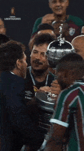 a group of men are holding a trophy that says libertadores